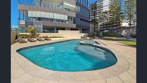 a large swimming pool in front of a building at Zenith Ocean Front Apartments Gold Coast - Official Listing in Gold Coast