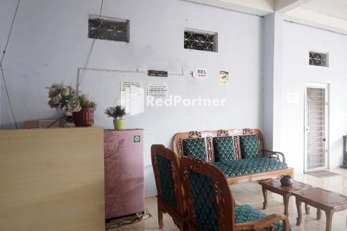 a room with chairs and a table and a counter at Tassa Homestay Syariah Mitra RedDoorz in Jambi