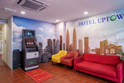a hotel lobby with a red couch and a ticket machine at Uptown Chinatown in Kuala Lumpur