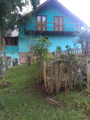 a blue house with a fence in front of it at Recanto Colina das Flores in Caeté