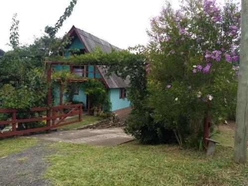 a house with a fence and flowers in front of it at Recanto Colina das Flores in Caeté