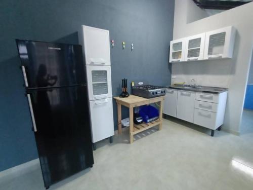 uma cozinha com um frigorífico preto e um fogão em casa vacacional campestre em Acacías