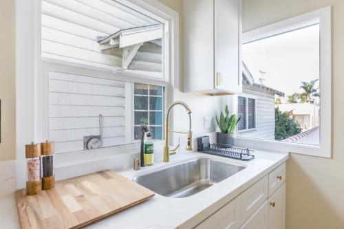 a white kitchen with a sink and a window at Cozy Sunny Brand-new Apt 1 Block From The Beach in Long Beach