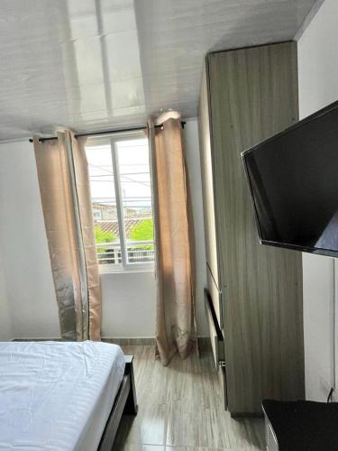 um quarto com uma cama e uma grande janela em Apacel em Cartago