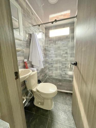 uma casa de banho com um WC, um lavatório e um chuveiro em Apacel em Cartago