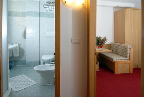 e bagno con servizi igienici, lavandino e doccia. di Hotel Zanon a Ziano di Fiemme