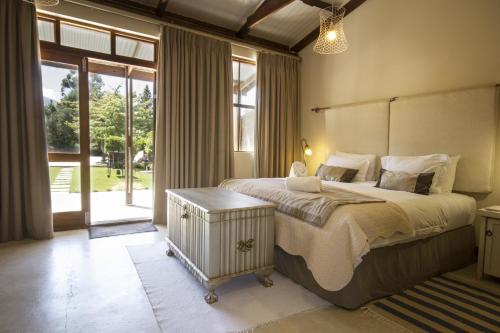 a bedroom with a large bed and a large window at A Hilltop Country Retreat in Swellendam