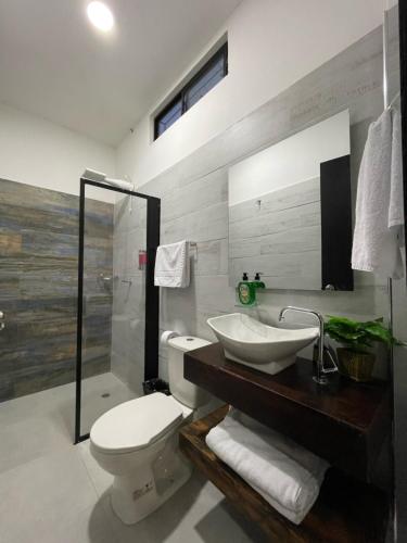 a bathroom with a white toilet and a sink at Amazonia Deluxe Calle 13 in Leticia