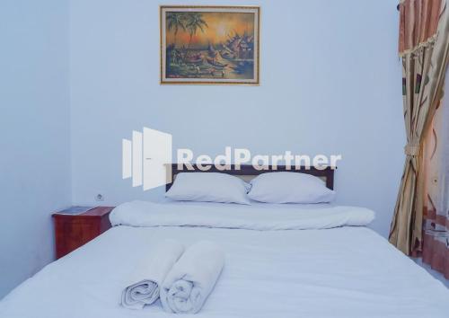 a bedroom with two beds with white sheets at MS Hotel Pangandaran Mitra RedDoorz in Pangandaran