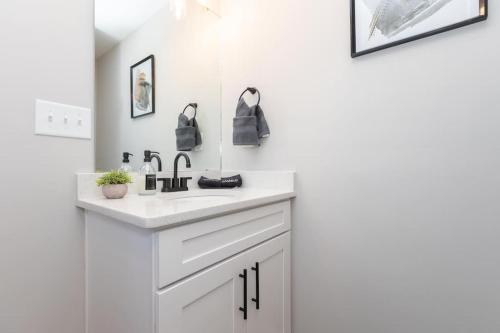 Baño blanco con lavabo y espejo en 3 Mi to City & Pet Friendly & Quiet Neighborhood en Charlotte