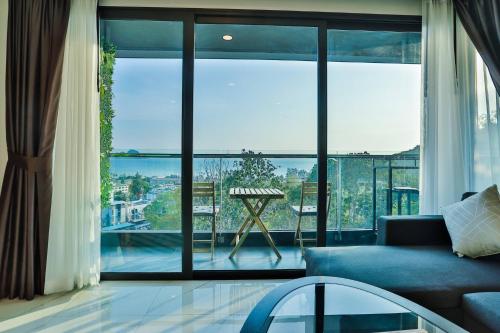 a living room with a blue couch and a large window at A503-Penthouse Amazing View 2brs3bedsAo Nang Beach Center in Ao Nang Beach