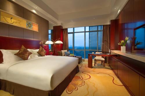 a bedroom with a large bed and a large window at Regal Airport Hotel Xi'an in Xianyang