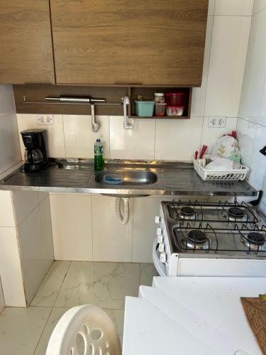 une cuisine avec une cuisinière et un évier dans l'établissement Refúgio no Paraíso, à Fernando de Noronha