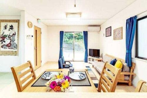 a living room with a dining room table and chairs at 我が家inOKINAWA 私の家in沖縄 in Onna