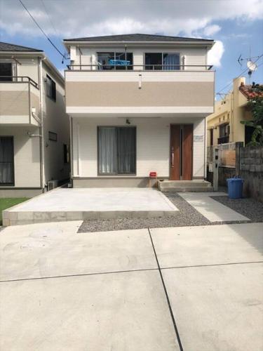 a large house with a driveway in front of it at 我が家inOKINAWA 私の家in沖縄 in Onna