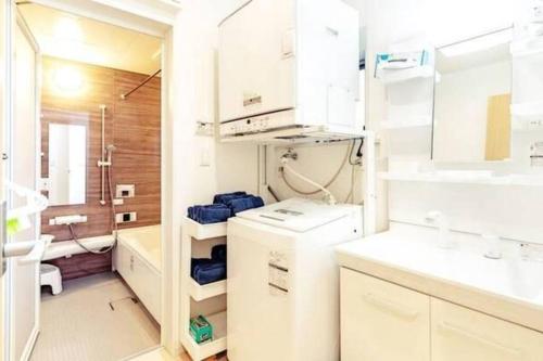 baño con armarios blancos y lavamanos en 我が家inOKINAWA 私の家in沖縄, en Onna