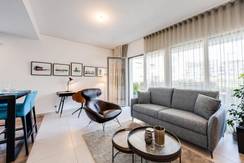 un salon avec un canapé et une table dans l'établissement L'Envolée - Charming T2 with terrace air conditioning, à Annecy