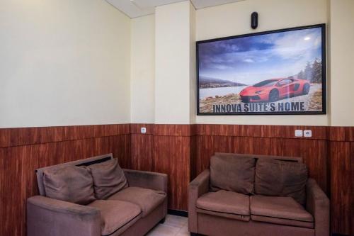 two chairs in a waiting room with a movie screen at RedDoorz near Taman Pantai Alam Indah Tegal in Tegal