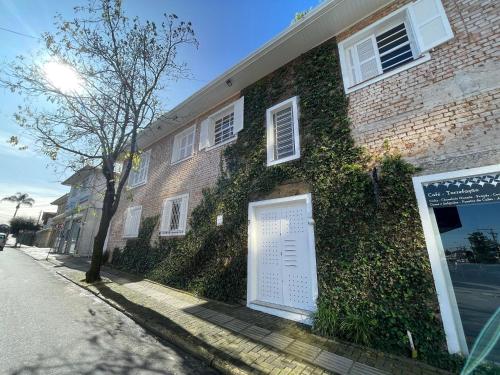 an ivy covered building with a sign in front of it at Prédio Histórico na Rio Branco in Caxias do Sul