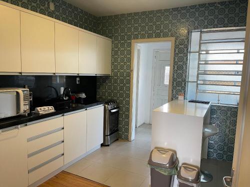 a kitchen with white cabinets and a counter top at Prédio Histórico na Rio Branco in Caxias do Sul