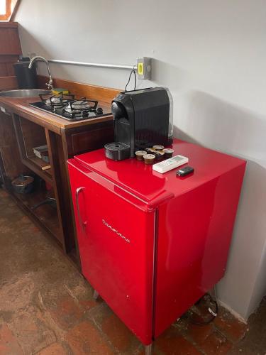 a red refrigerator with a microwave on top of it at Prédio Histórico na Rio Branco in Caxias do Sul
