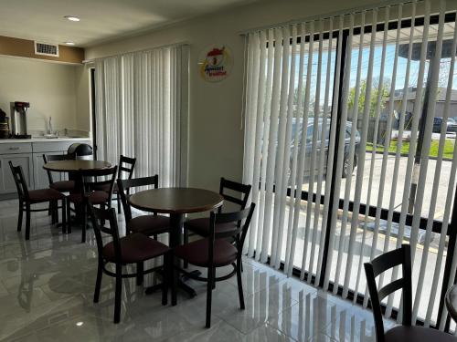 a dining room with tables and chairs and a large window at Super 8 by Wyndham Slidell in Slidell