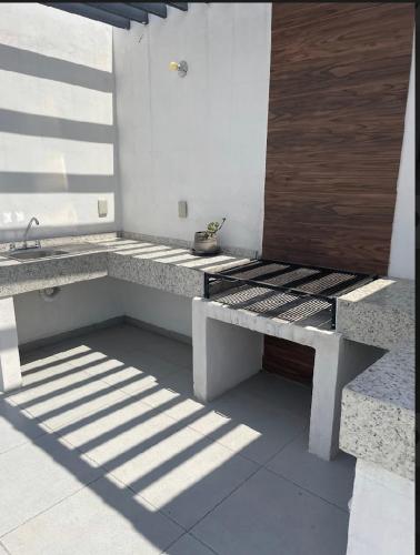 a bench sitting on the side of a building at Acogedora y amplia casa, alberca climatizada previa reserva in Juriquilla