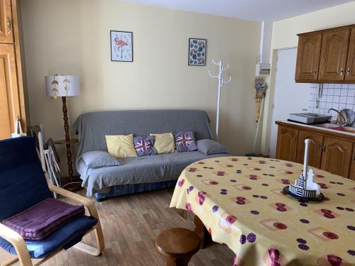 un salon avec un canapé et une table dans l'établissement Appartement Centre de Fort-Mahon-Plage : 2 Chambres, Balcon Sud, Plage et Commerces à Proximité - FR-1-482-112, à Fort-Mahon-Plage