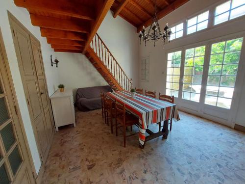une salle à manger avec une table et quelques chaises dans l'établissement Maison de village spacieuse à 70m de la plage, 200m des commerces, grande terrasse, 10 couchages - FR-1-423-273, au Grau-dʼAgde