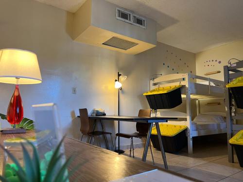 a room with a bunk bed and a table and a desk at Bposhtels Hollywood Florida in Hollywood