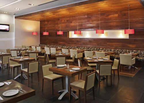 un ristorante con pareti e tavoli in legno e sedie di Casa Inn Premium Hotel Queretaro a Querétaro