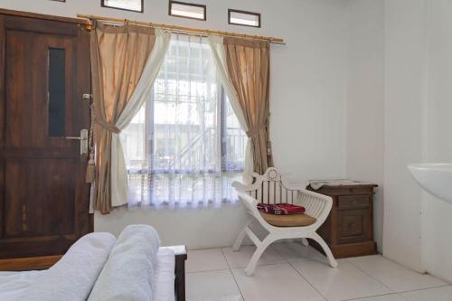 a living room with a chair and a window at Erika Homestay in Lembang