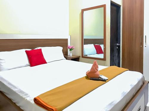 Akavi Homestay Jayapura Redpartner في جايابورا: غرفة نوم مع سرير أبيض كبير مع مرآة