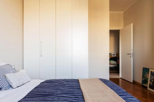 米蘭的住宿－Schiavoni Flexyrent WiFi，一间卧室配有一张带蓝白色毯子的床