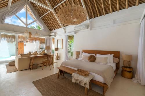 a bedroom with a bed and a desk in a room at Amaka Villas in Uluwatu