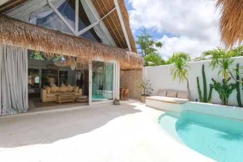 a villa with a swimming pool and a living room at Amaka Villas in Uluwatu