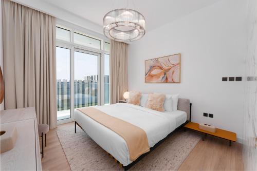 a white bedroom with a bed and a large window at Maison Privee - Deluxe 3BR Apt with Dubai Marina Vws & Beach Access in Dubai