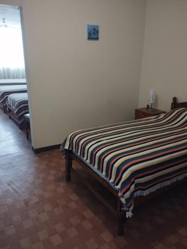una fila de camas alineadas en una habitación en Departamento Amoblado en Urba. Ilo, en Ilo
