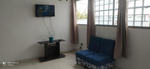 a living room with a blue chair and a table at APARTAESTUDIO SENDERO PRIMAVERA 2 in Neiva