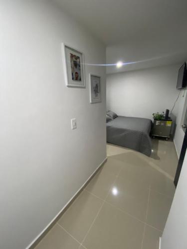 a bedroom with a bed and a white floor at Apartaestudio de 1 habitación Disfruta Medellin in Medellín
