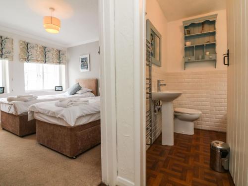 1 dormitorio con 2 camas y lavamanos en Crab Cottage, en Ilfracombe
