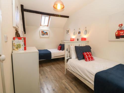 mały pokój z 2 łóżkami i lodówką w obiekcie Y Bwthyn Ty Du w mieście Llannor