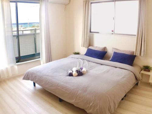 a teddy bear laying on a bed in a bedroom at ZZOKIAI Premier Ou奥武壹号B棟 奥武岛上能看见海的新建一户建 走到海滩只有1分钟 walk to beach only 1 minute in Shikenbaru