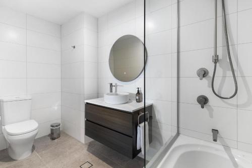 a white bathroom with a sink and a mirror at Beacon Lakeside Luxury 908 - 3 Bedroom in Queenstown
