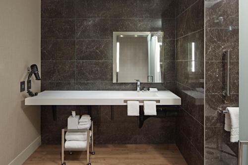 a bathroom with a sink and a mirror at AC Hotel by Marriott Minneapolis Downtown in Minneapolis