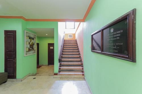 Una televisión o centro de entretenimiento en Urbanview Hotel Taman Suci Denpasar Bali