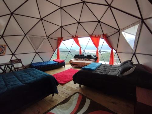 a room with two beds in a igloo with windows at Glamping Bella Vista in Guatavita