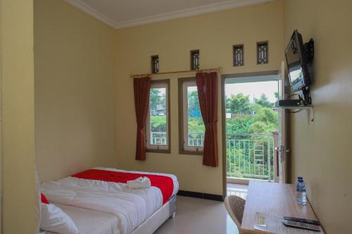 a bedroom with a bed and a large window at RedDoorz Syariah near Taman Rekreasi Kalianget Wonosobo in Kalianget