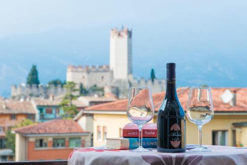 a bottle of wine and two wine glasses on a table at Hotel Erika in Malcesine