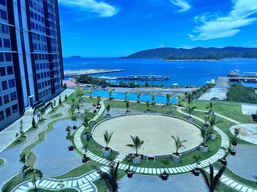 an aerial view of a park with palm trees and the ocean at Splendours Condos@Jesselton Quay in Kota Kinabalu